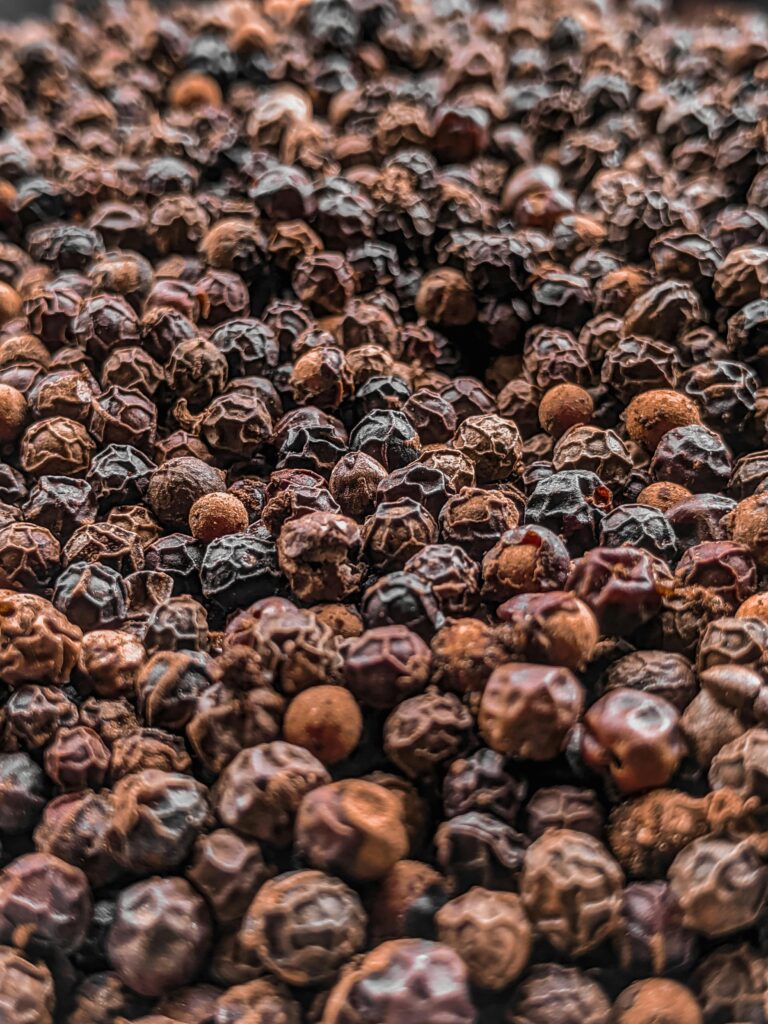 A detailed close-up shot of black peppercorns showcasing their texture and pattern.